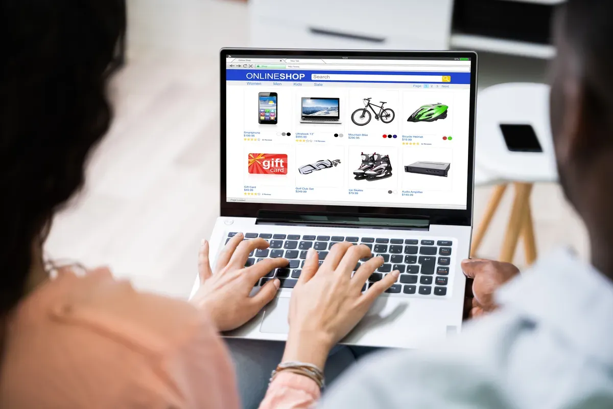 Dizüstü bilgisayarda bir online mağazanın ürün sayfasına birlikte göz atan iki kişi
