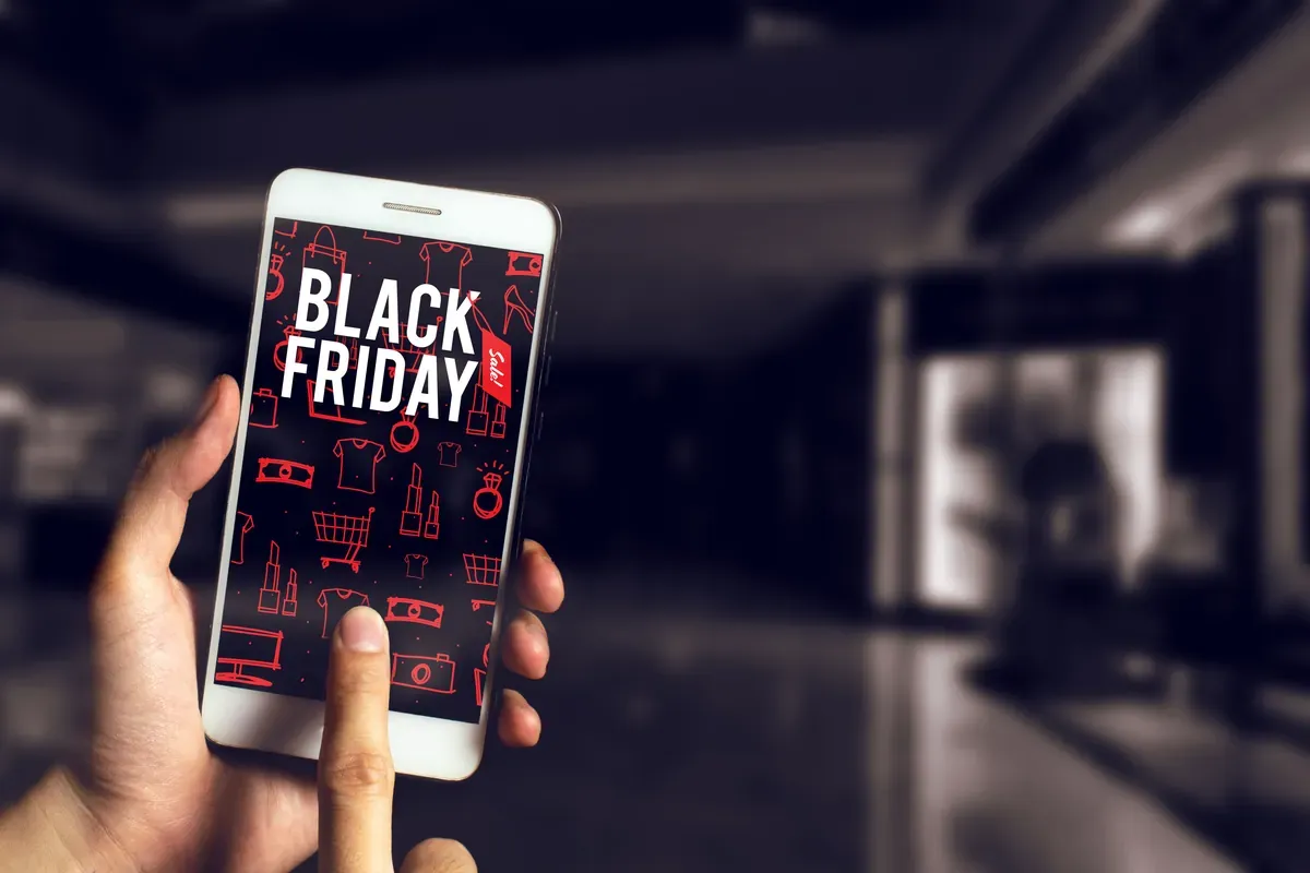 Akıllı telefon ekranında Black Friday indirim kampanyasına göz atan bir alışverişçinin eli